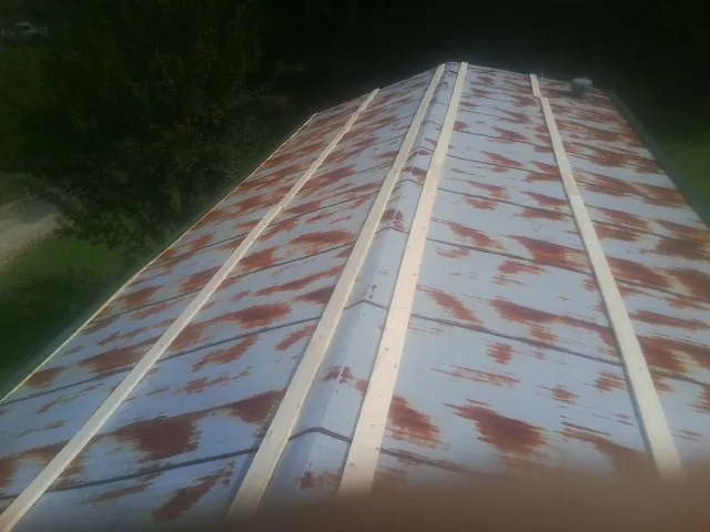 Rusted metal roof panels with new wood purlins before replacement — Storm Damage Roof Repair in Robeline by Roofing Brothers