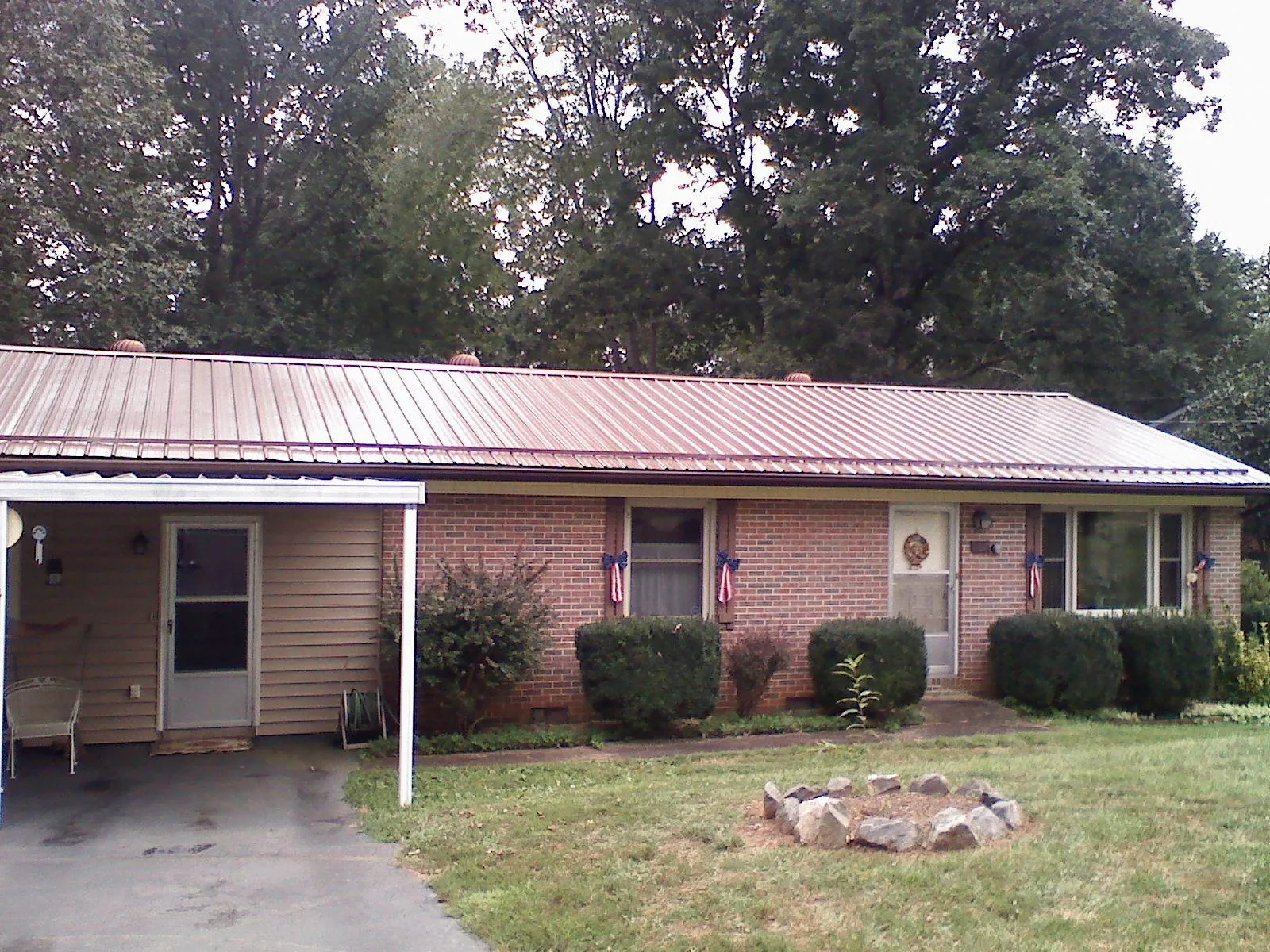 Bronze metal roof and carport on a brick ranch home — Roof Repair work by our crew in Robeline